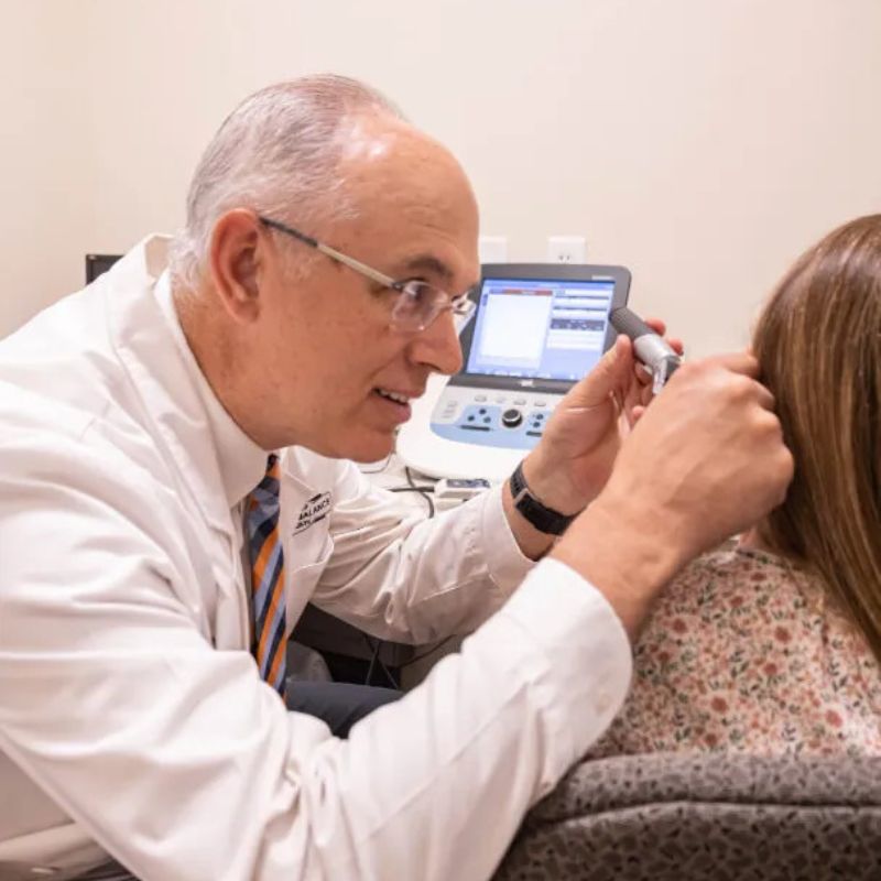 audiologist checking a patient's ear